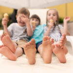 Pies de niños en primer plano que están tomando helado